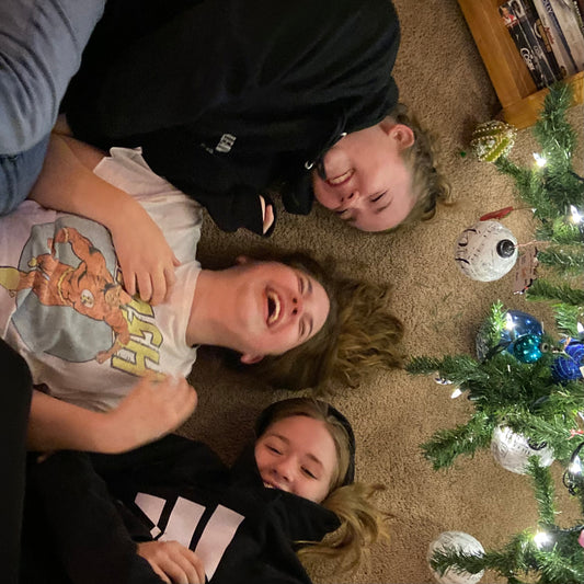 three kids under the christmas tree