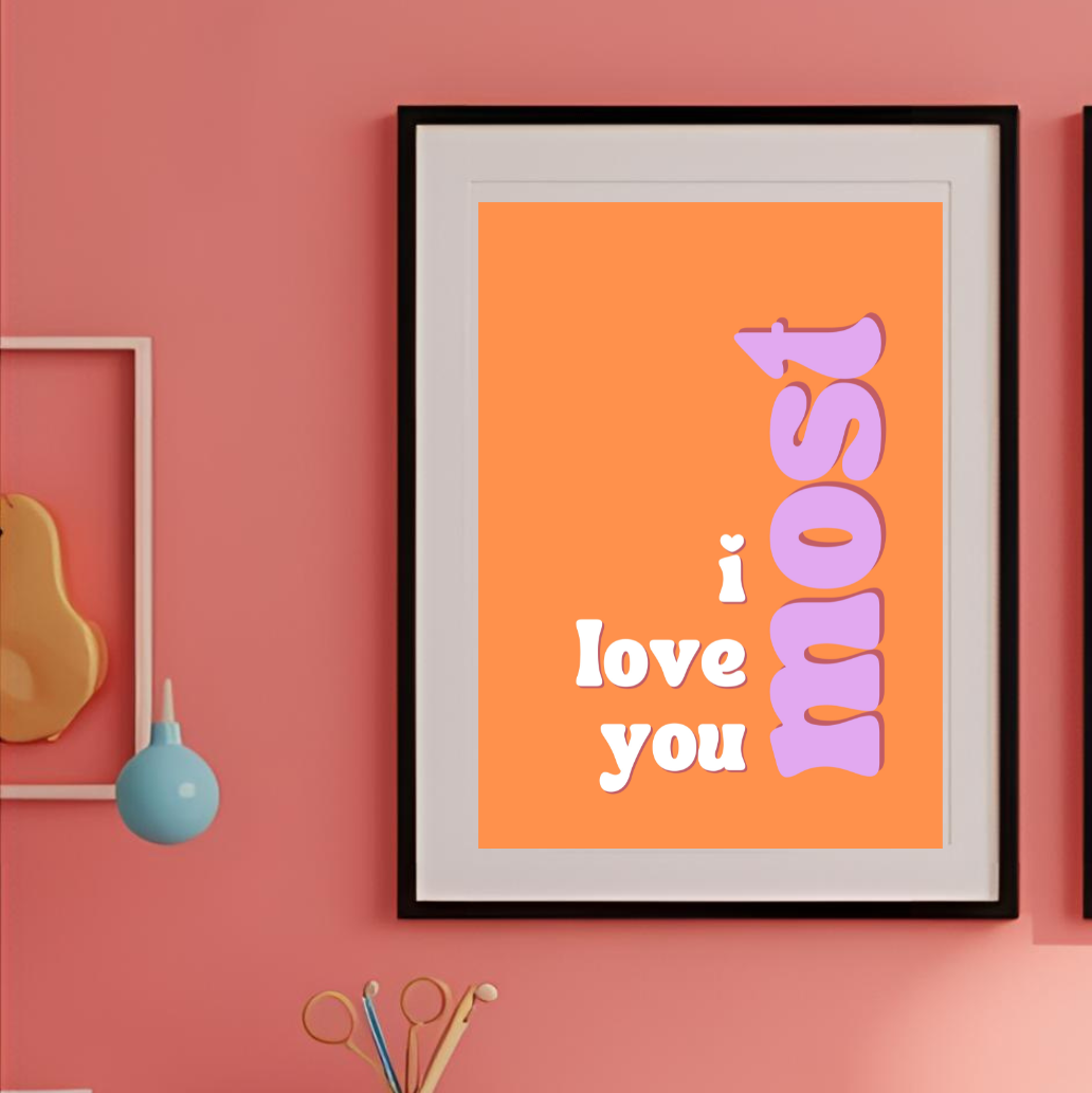 Three framed posters on a pink wall with a chair and small table in the foreground.