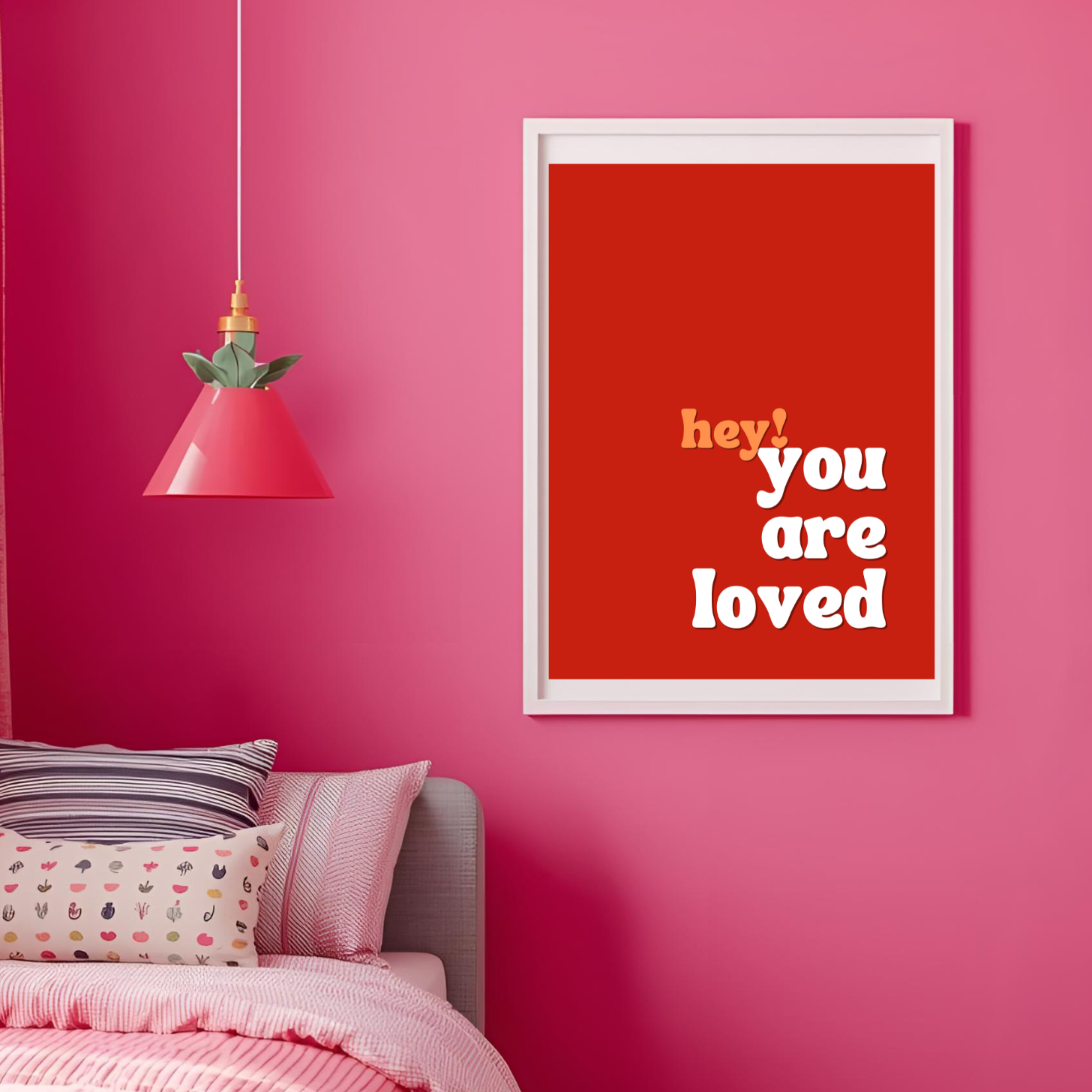 Framed poster with 'hey you are loved' text on a pink wall.